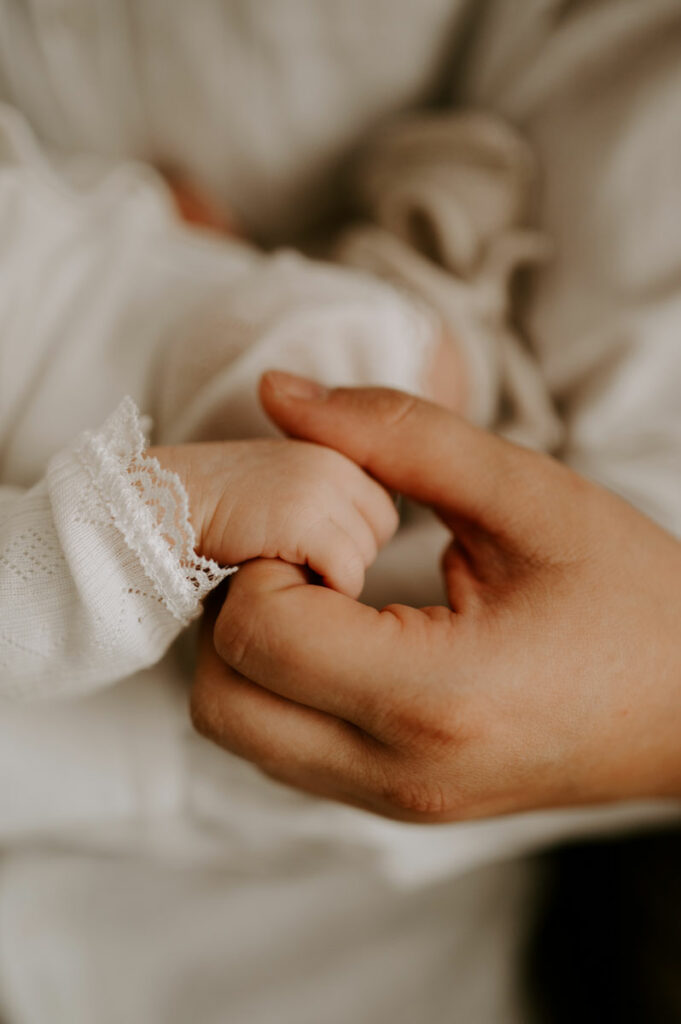 Newbornfotografie mama houdt hand vast
